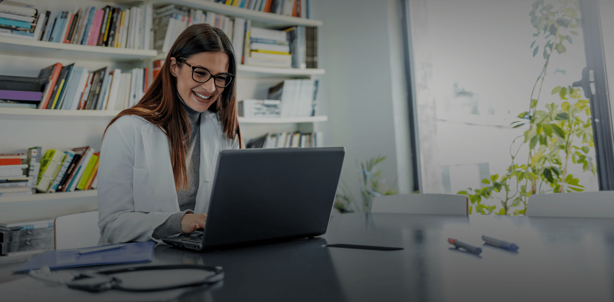 Nutricionista sorrindo em frente ao computador